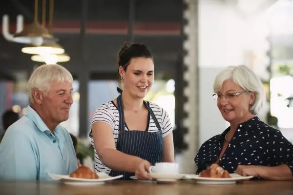 Cropped shot of a senior couple being served by a waitress.